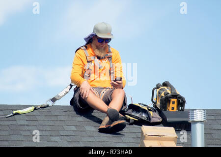 Pannello solare installatori prendendo una pausa sulla cima di un tetto. Foto Stock