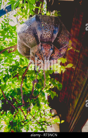 Sun flare su vecchi lampada di antiquariato con decorazioni arabe, appeso all'aperto con la sunflare Foto Stock