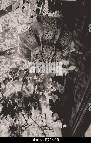 Sun flare su vecchi lampada di antiquariato con decorazioni arabe, appeso all'aperto con la sunflare Foto Stock