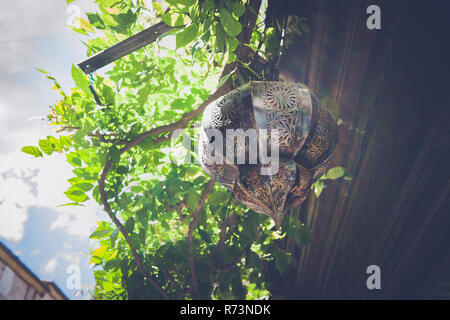 Sun flare su vecchi lampada di antiquariato con decorazioni arabe, appeso all'aperto con la sunflare Foto Stock