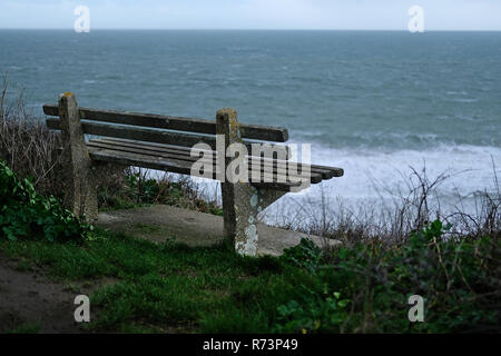 Un sedile vuoto, panca, guardando il mare in un freddo giorno di inverno in Cornwall​, UK. Foto Stock