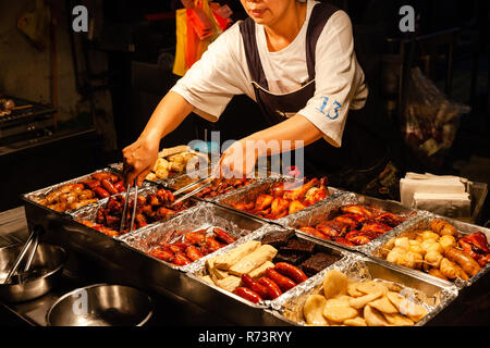 JIUFEN, Taiwan - 6 novembre: una donna vende cinese tradizionale snack presso la strada del mercato di Jiufen il 6 novembre 2018 in Jiufen, Taiawan. Foto Stock