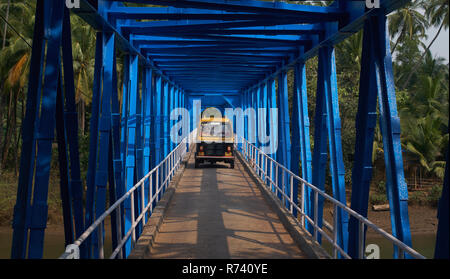 Un rickshaw guida su un ponte in Goa, India, Foto Stock