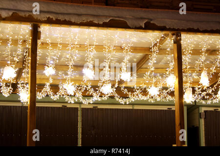Favola di natale luci sotto il padiglione nevoso tetto Foto Stock