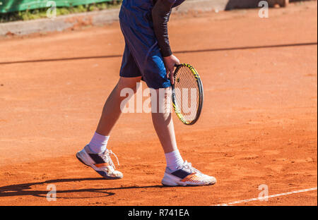 Giovane giocatore di tennis di concentrare e tenetevi pronti per tornare a servire dal lettore opposta. Foto Stock