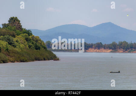 Don Daeng, Laos - Aprile 27, 2018: barca da pesca con la navigazione del Mekong circondato da verdi foreste e montagne Foto Stock