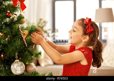 Bambina decorare albero di Natale a casa Foto Stock