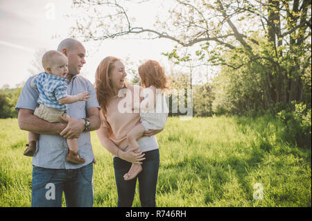 I genitori e i bambini che prendono a piedi in posizione di parcheggio Foto Stock