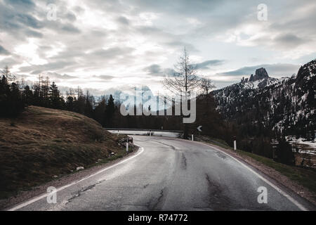 Strada rurale nelle montagne innevate, Dolomiti, Italia Foto Stock
