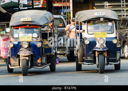 Due di tuk-tuk driver di attesa per i passeggeri con i loro tuk-tuks parcheggiato di fronte a loro, Chiang Mai, Thailandia Foto Stock