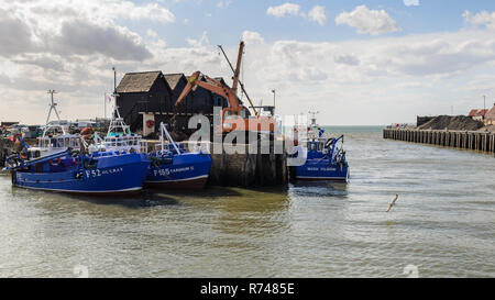 Whitstable, England, Regno Unito - 6 Giugno 2015: una flotta di barche da pesca sono ormeggiati ad una banchina accanto a pescatori tradizionali capanne in Whitstable Harbour su Foto Stock