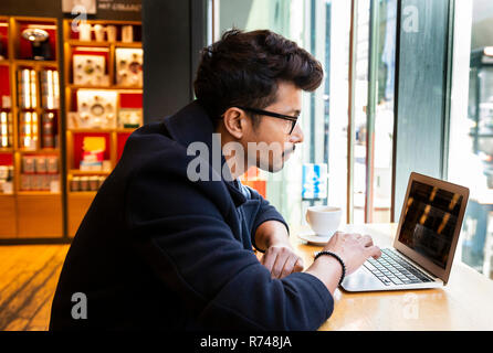 Uomo d affari con computer portatile in cafe Foto Stock