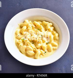 Close up di maccheroni e formaggio in ciotola bianco su blu tavolo di pietra Foto Stock