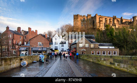 Durham, Regno Unito - 29 Gennaio 2017: pomeriggio sole illumina il castello di Durham Durham sopra la città, dove i pedoni a piedi su Silver Street Bridge. Foto Stock