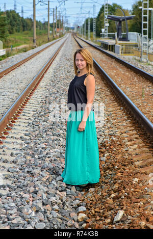 Ragazza permanente tra due percorso ferroviario Foto Stock