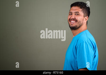 Persiano barbuto uomo che indossa maglietta blu contro backgroun colorati Foto Stock