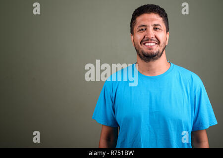 Persiano barbuto uomo che indossa maglietta blu contro backgroun colorati Foto Stock