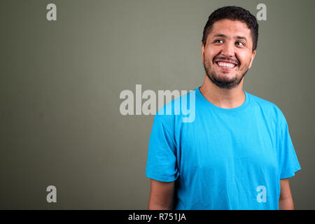 Persiano barbuto uomo che indossa maglietta blu contro backgroun colorati Foto Stock