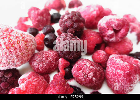 Un gruppo di frutti di bosco surgelati (lamponi, more e bacche blu e fragole) su yoogurt. Foto Stock