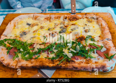 Pizza Napoletana sul tavolo del ristorante. Italian pizza fresca sul piatto di legno. Quattro Formaggi, margarita. Foto Stock
