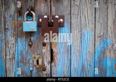 Due blocchi sul vecchio vintage in legno porta di garage, peeling paint Foto Stock