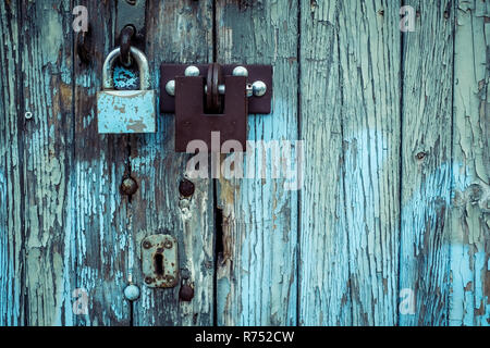 Due blocchi sul vecchio vintage in legno porta di garage, peeling paint Foto Stock