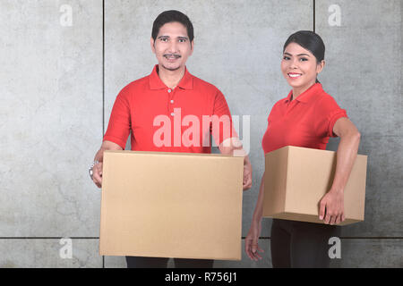 Giovani asiatici delivery service team con il pacco in piedi Foto Stock