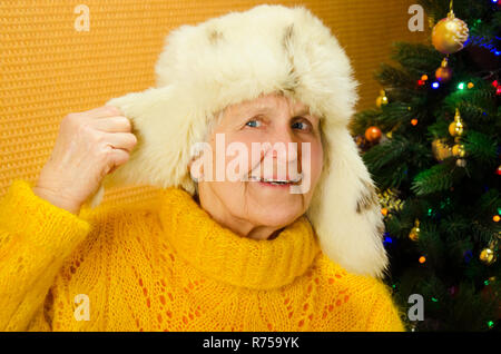 Positivo femmina senior è esprimere la felicità in vacanza. Ritratto di nonna felice su decorate Anno nuovo albero, buon Natale concetto, famiglia felice, lifestyle indoor, Foto Stock