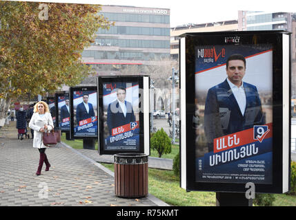 Eriwan, Armenia. 08 Dic, 2018. Una donna cammina passato elezioni manifesti raffiguranti i candidati del 'My Passo" il movimento del primo ministro N. Pashinjan. Nella ex repubblica sovietica di Armenia un nuovo Parlamento sarà eletto il 08.12.2018. Con le elezioni anticipate, il capo del governo vuole ottenere la maggioranza nell'Assemblea nazionale al fine di attuare le riforme promesse. Circa 2,5 milioni di persone sono chiamati a votare. Credito: Christian Thiele/dpa-Zentralbild/dpa/Alamy Live News Foto Stock