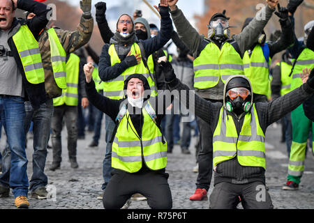 Parigi, Francia. L'8 dicembre, 2018. " Giallo " canottiere manifestanti gridare slogan vicino all'Arco di Trionfo a Parigi, Francia, a 8 Dicembre, 2018. Sommossa la polizia ha sparato gas lacrimogeni e cannoni ad acqua a 'giallo' giubbotti di manifestanti marciano a Parigi il sabato nel quarto week-end azione nonostante il Presidente Emmanuel Macron la serie di concessioni. Credito: Chen Yichen/Xinhua/Alamy Live News Foto Stock