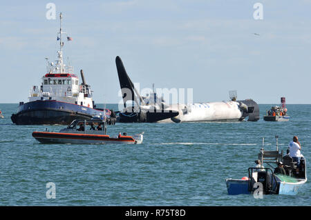 Port Canaveral, Florida, Stati Uniti d'America. Dicembre 7, 2018. Dopo manca la zona di atterraggio uno alla Cape Canaveral Air Force Station dopo il lancio della SpaceX stadio pugno Falcon 9 crash a razzo sbarcati nell'Oceano Atlantico vicino alla riva. SpaceX recuperato il booster con un locale dive team, fissato il razzo flottante e trainato torna alla porta. Una pesante flottiglia di sicurezza e supporto di barche era a portata di mano per assicurarsi di operazione è stata effettuata in modo sicuro. Credito foto Julian Porro / Alamy Live News Foto Stock