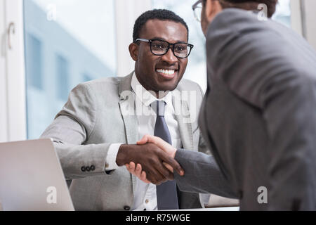 Vista ravvicinata di sorridere imprenditori multietnica stringono le mani in office Foto Stock