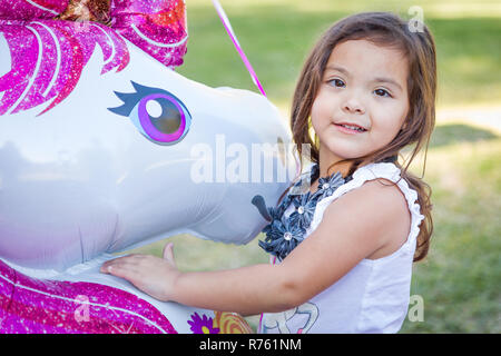 Carino giovane razza mista Baby Ragazza con palloncino in Mylar all'esterno. Foto Stock