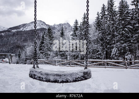 Swing vuota nel periodo invernale con la neve. Foto Stock