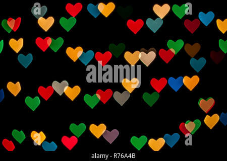 A forma di cuore ad qustom bokeh creato da luci di decorazione e isolate su sfondo nero. Foto Stock