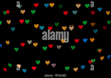 A forma di cuore ad qustom bokeh creato da luci di decorazione e isolate su sfondo nero. Foto Stock