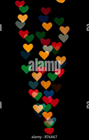 A forma di cuore ad qustom bokeh creato da luci di decorazione e isolate su sfondo nero. Foto Stock