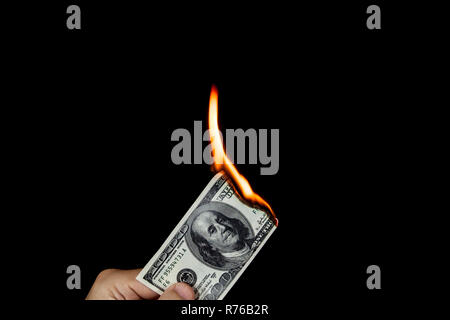 Mano umana tenendo un ardente 100 dollari Foto Stock