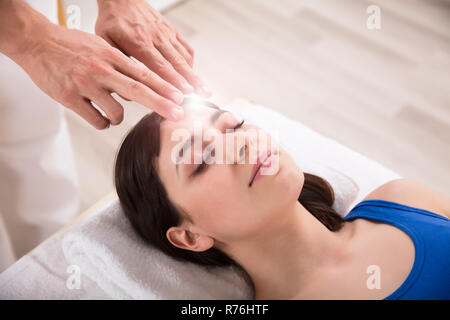 Terapista esegue reiki guarigione trattamento sulla donna Foto Stock