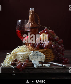 Vino rosso con formaggio blu, limone uva e melograno Foto Stock