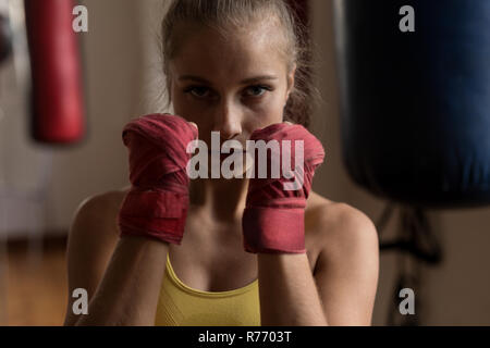 Boxer femmina formando il pugno a mano in studio fitness Foto Stock