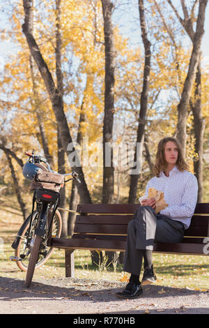 L'uomo rilassante sulla panchina nel parco Foto Stock