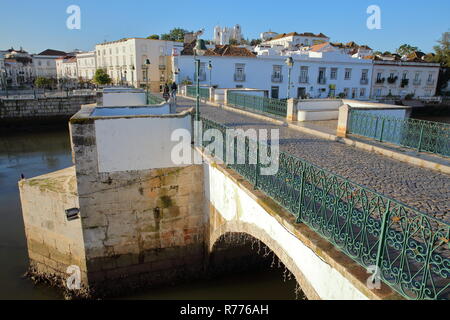 La forma arcuata ponte romano sul fiume Rio Gilao, Tavira, Algarve, Portogallo, con la città vecchia in background Foto Stock