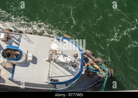 Overhead POV vista del rimorchiatore a traino, funi e lavoratori assistere grandi navi di attraccare in venti alti su un luminoso giorno di sole. Canale Gastineau, Juneau, Alaska, U Foto Stock