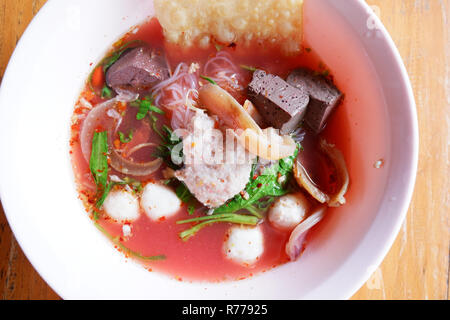 Tagliatelle con frutti di mare sulla zuppa rossa / piccante e speziato cibo thai noodle pesce carne di maiale di calamaro pesci palla e gloria di mattina croccante raviolo wonton in salsa rossa zuppa Foto Stock