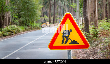 Temporaneo di cartello stradale che indica il lavoro su una piccola strada nella foresta Foto Stock