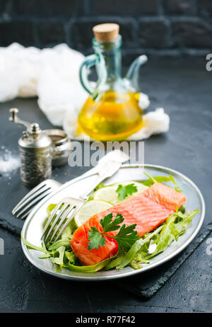 Salmone con insalata fresca sulla piastra Foto Stock