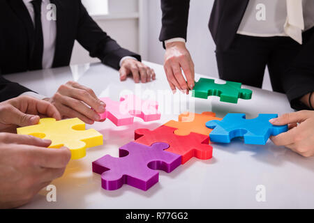 Gruppo di imprenditori risolvendo puzzle Foto Stock