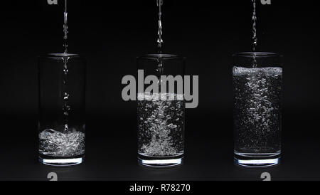 Vuoto, mezzo pieno e pieno di acqua in vetro isolato su sfondo nero Foto Stock