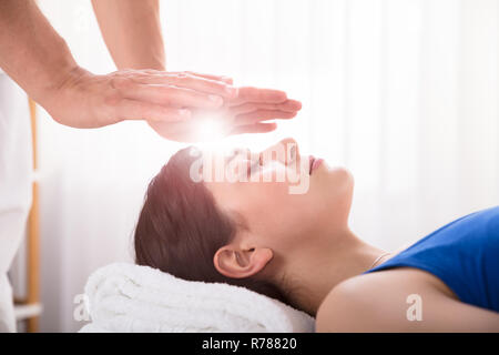 Terapista esegue reiki guarigione trattamento sulla donna Foto Stock